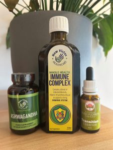 tall bottle of Whealth Health Immune Complex food supplement alongside a jar of Ashwagandha capsules and a bottle of Transition Essence